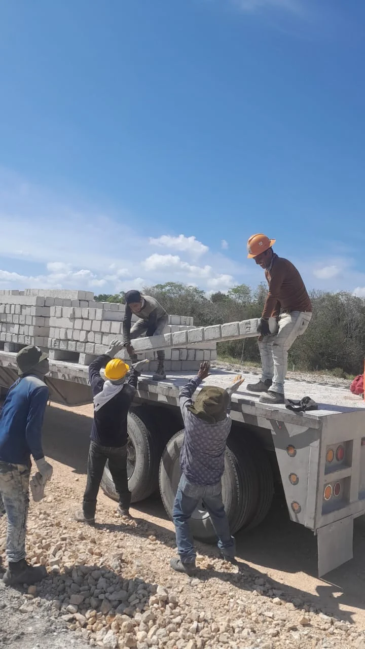 Unloading concrete posts on site · Tren Maya